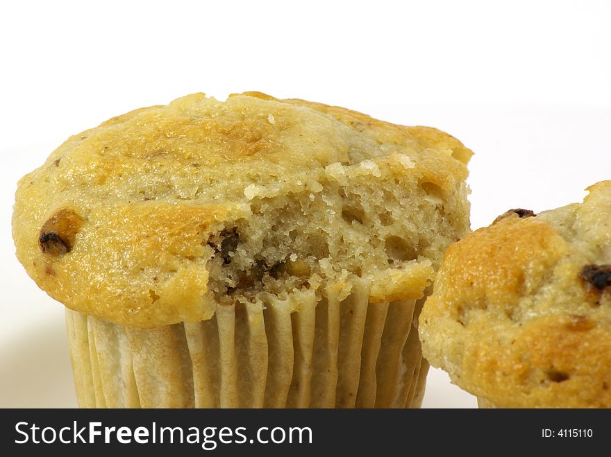 Fresh baked moist banana nut muffins on white plate and background.