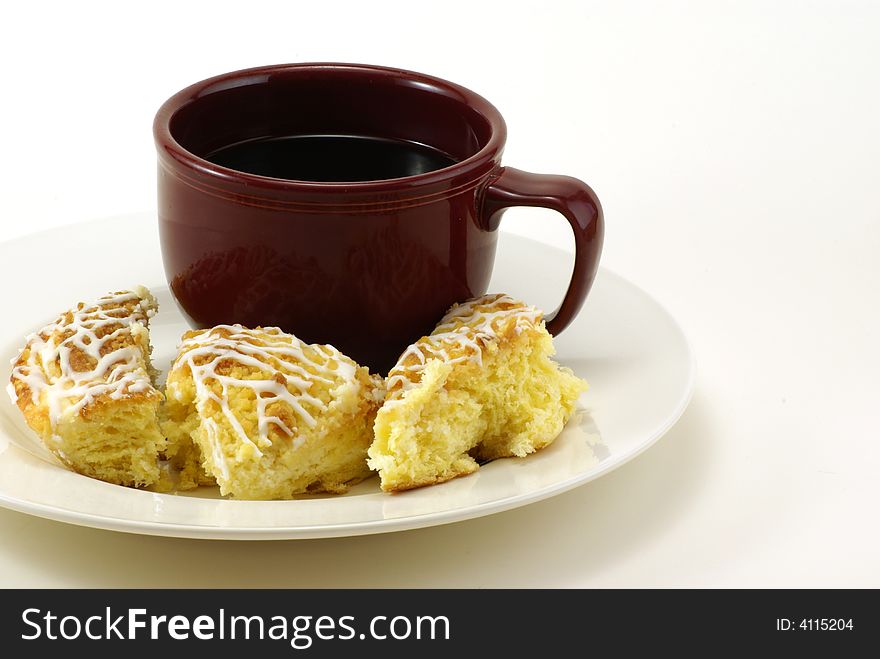 Large mug of coffee with pieces of streusel coffee cheese crumb cake on white plate with white background. Large mug of coffee with pieces of streusel coffee cheese crumb cake on white plate with white background.
