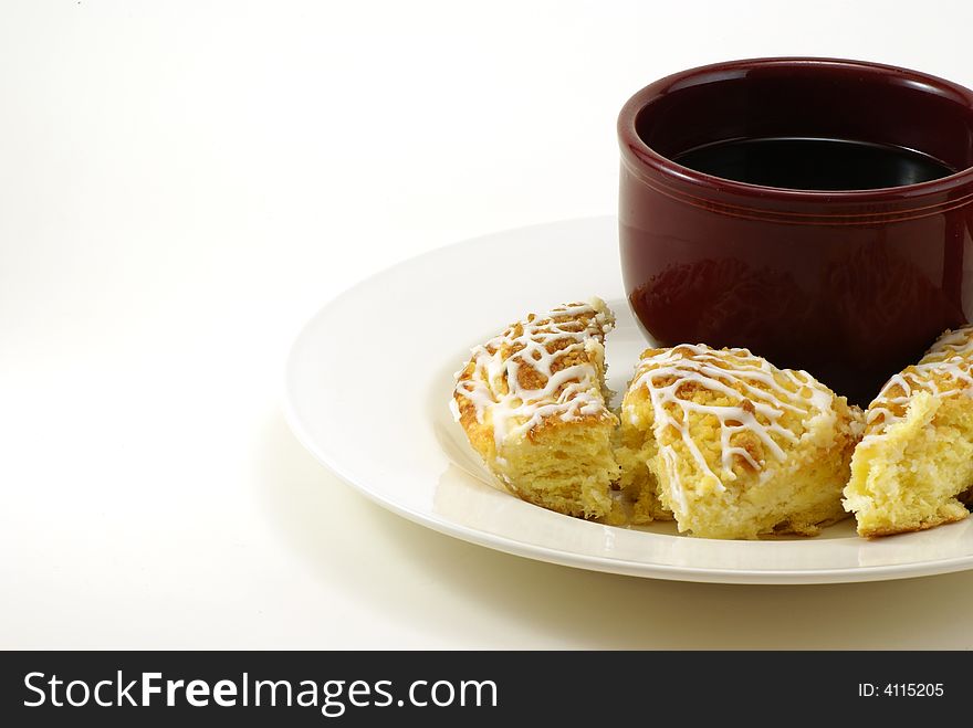 Large mug of coffee with pieces of streusel coffee cheese crumb cake on white plate with white background. Large mug of coffee with pieces of streusel coffee cheese crumb cake on white plate with white background.