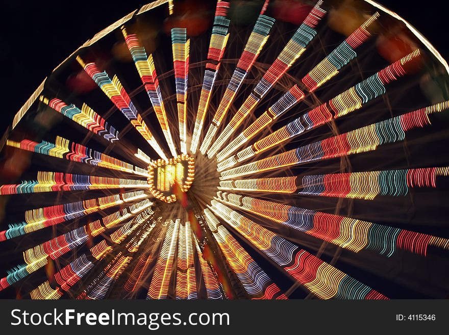A Ferris Wheel blurred with motion, shot at night during a Carnival. A Ferris Wheel blurred with motion, shot at night during a Carnival.