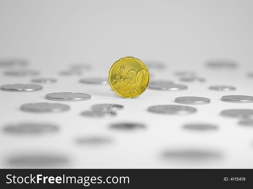 Single euro coin of twenty cents standing on a money field. Single euro coin of twenty cents standing on a money field