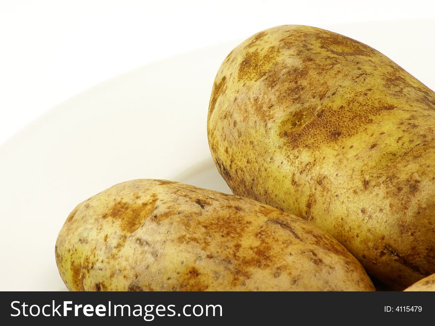 Whole raw uncooked white potatos with skins on. Whole raw uncooked white potatos with skins on.