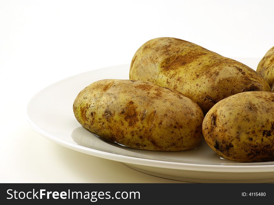 Whole raw uncooked white potatos with skins on. Whole raw uncooked white potatos with skins on.