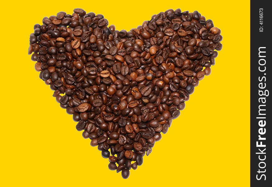 Beans of coffee in the form of heart on a yellow background