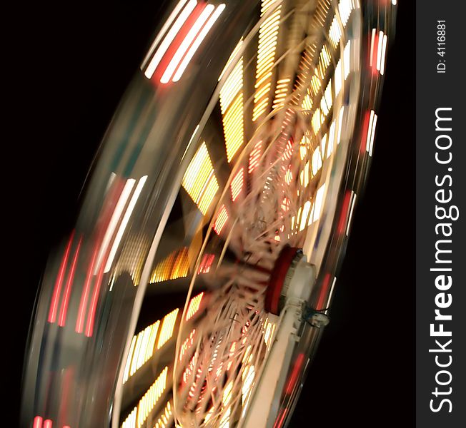 A Ferris Wheel blurred with motion, shot at night during a Carnival. A Ferris Wheel blurred with motion, shot at night during a Carnival.