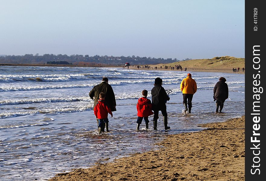 Family walking on Camber Beach, UK in winter sunshine. Family walking on Camber Beach, UK in winter sunshine.