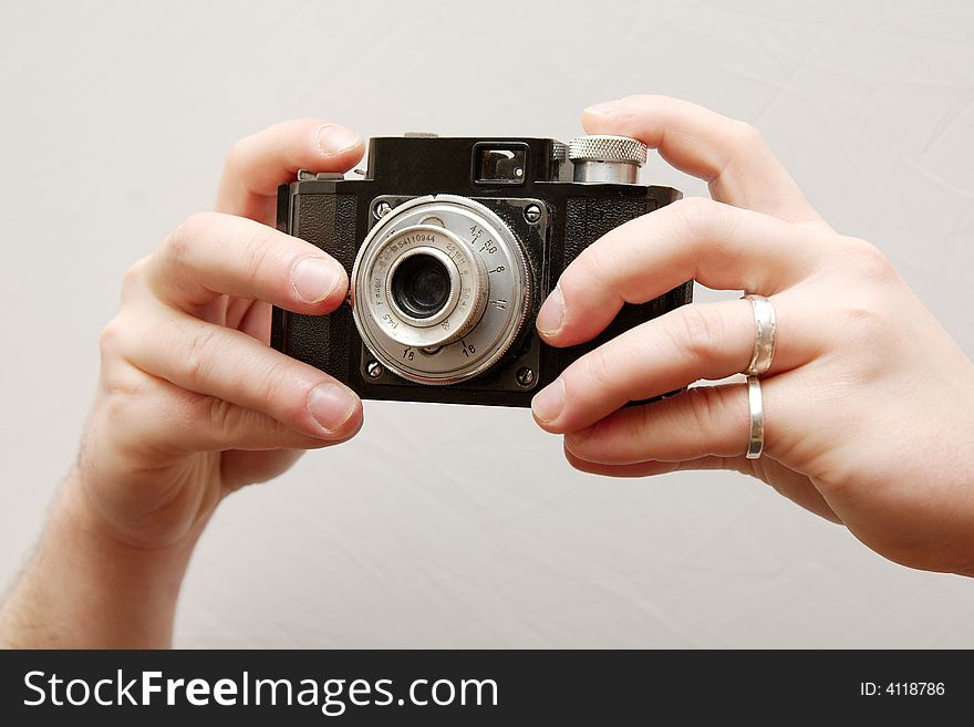 Hands holding an old camera isolated