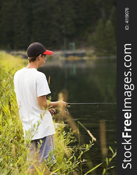 Boy out fishing at a small mountian lake. Boy out fishing at a small mountian lake