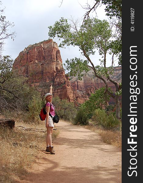 Young tourist woman showing Angel's Landing Point in the Zion National Park, USA