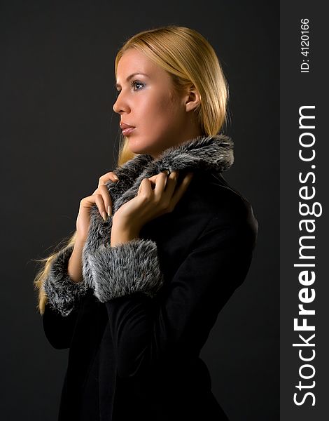 Woman in fur lined winter coat over dark background