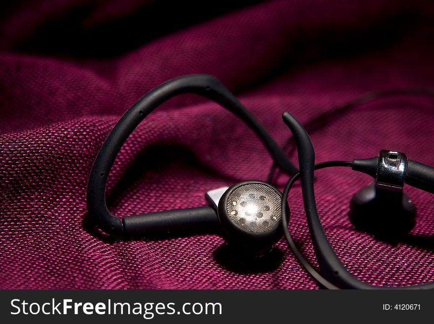 Black earphones macro details on the red backgrouund