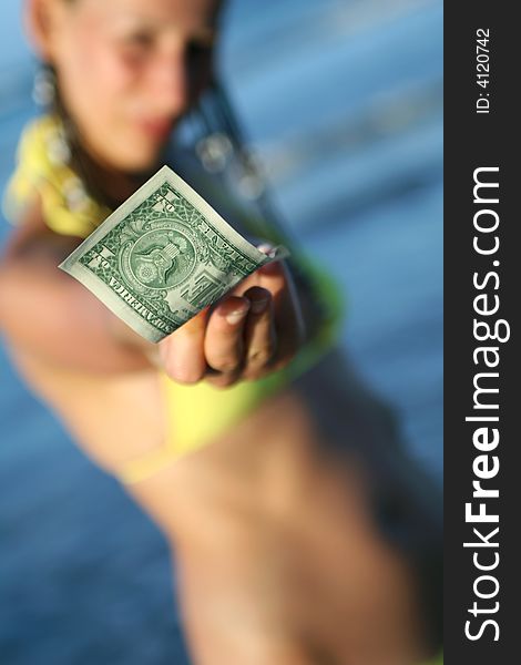 Bikini clad woman holding dollar in the hand