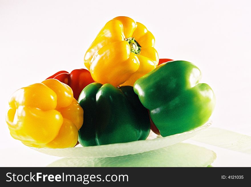A bowl of yellow, green and red capsicum.