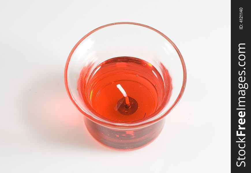 Top view of bright red candle in glass