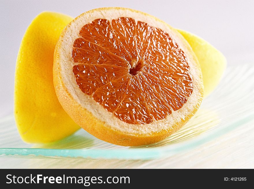A close up view of a sliced grapefruit on a plate. A close up view of a sliced grapefruit on a plate