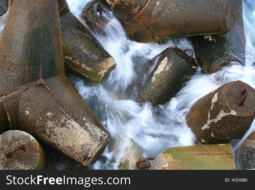 Waves fight about a concrete obstacle in a bay