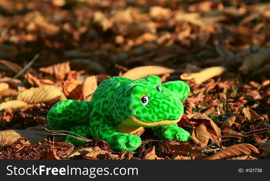 Green toy in yellow leaves. Green toy in yellow leaves