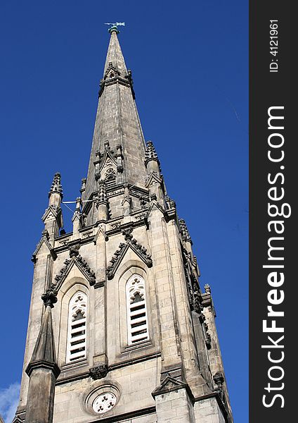A tall church steeple against a bright blue sky.