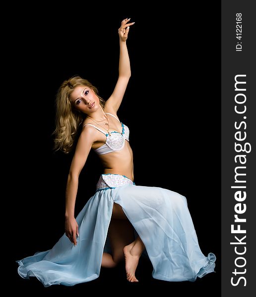 Attractive girl dances east dance isolated on a black background. Attractive girl dances east dance isolated on a black background