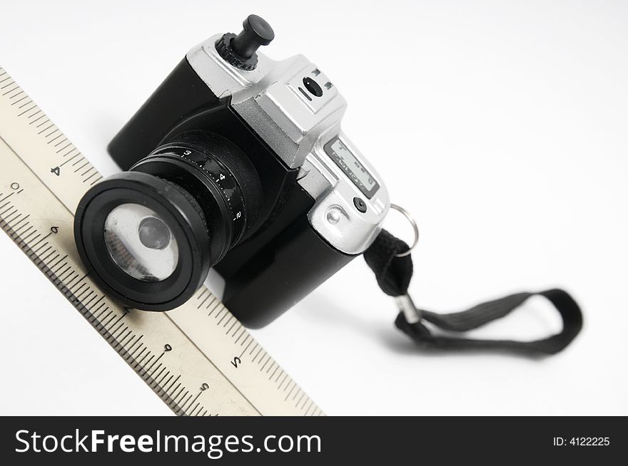 A ruler and a miniature camera lighter. A ruler and a miniature camera lighter