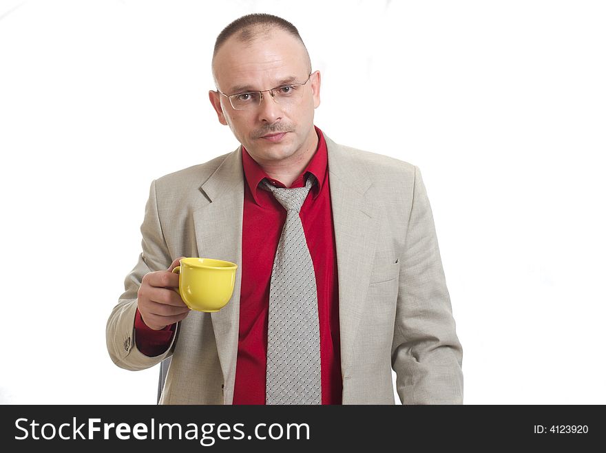 The man holds a yellow cup with tea. The man holds a yellow cup with tea