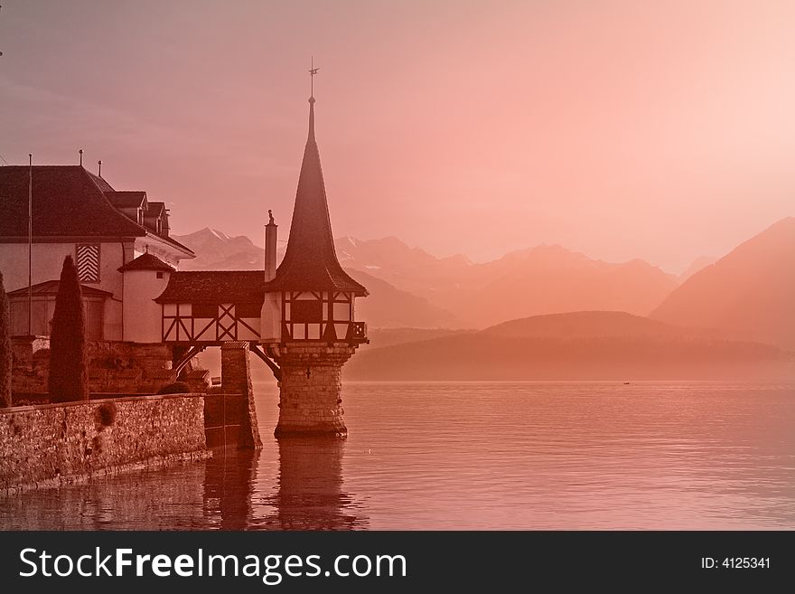 Old swiss castle Oberhoften in the morning light on the lake of Thun,  Alps Switzerland. Old swiss castle Oberhoften in the morning light on the lake of Thun,  Alps Switzerland