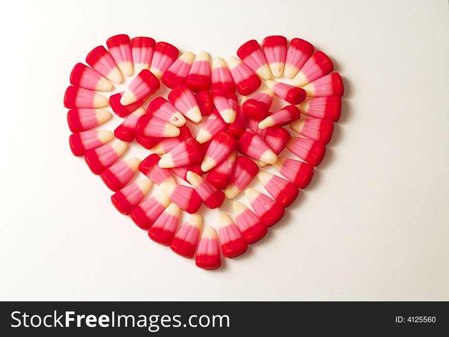 Candy Corns shaped in to a heart on a white background. Candy Corns shaped in to a heart on a white background.