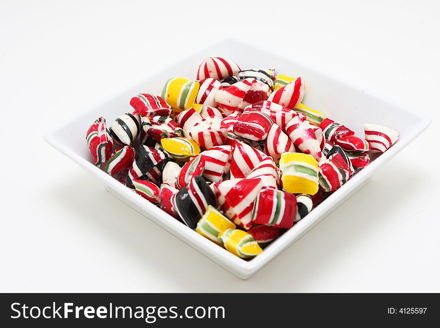 A bowl of hard candy shot on white, very colorful and saturated colors. A bowl of hard candy shot on white, very colorful and saturated colors