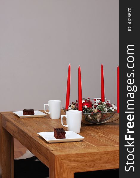 Table decorated with christmas decoration, set with cups of cocoa and chocolate cakes. Table decorated with christmas decoration, set with cups of cocoa and chocolate cakes