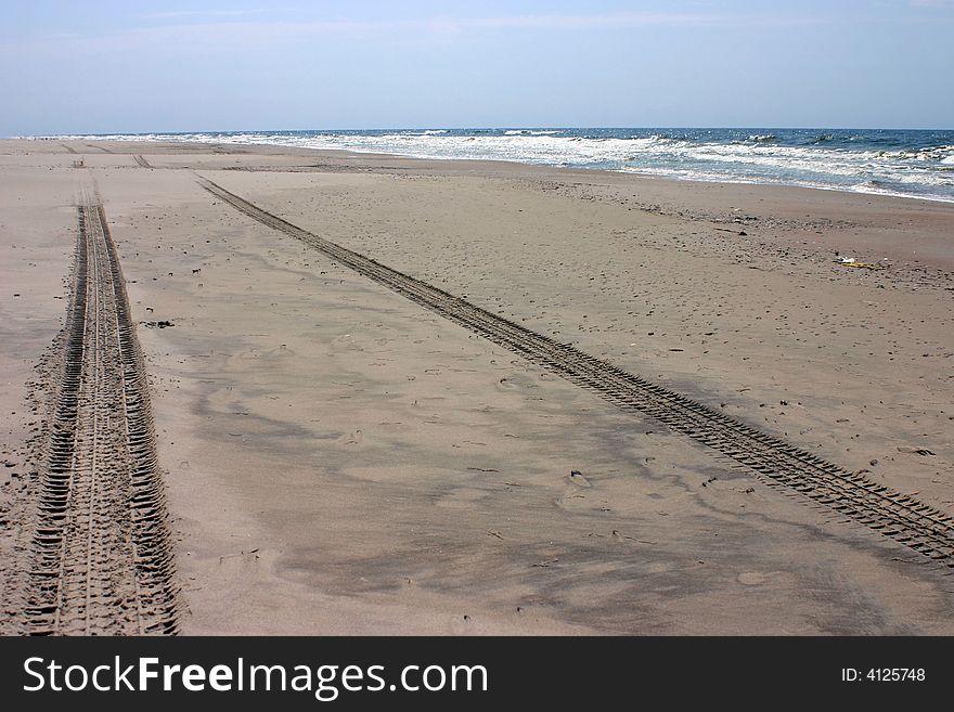 Wheel tracks on the empty beach sand