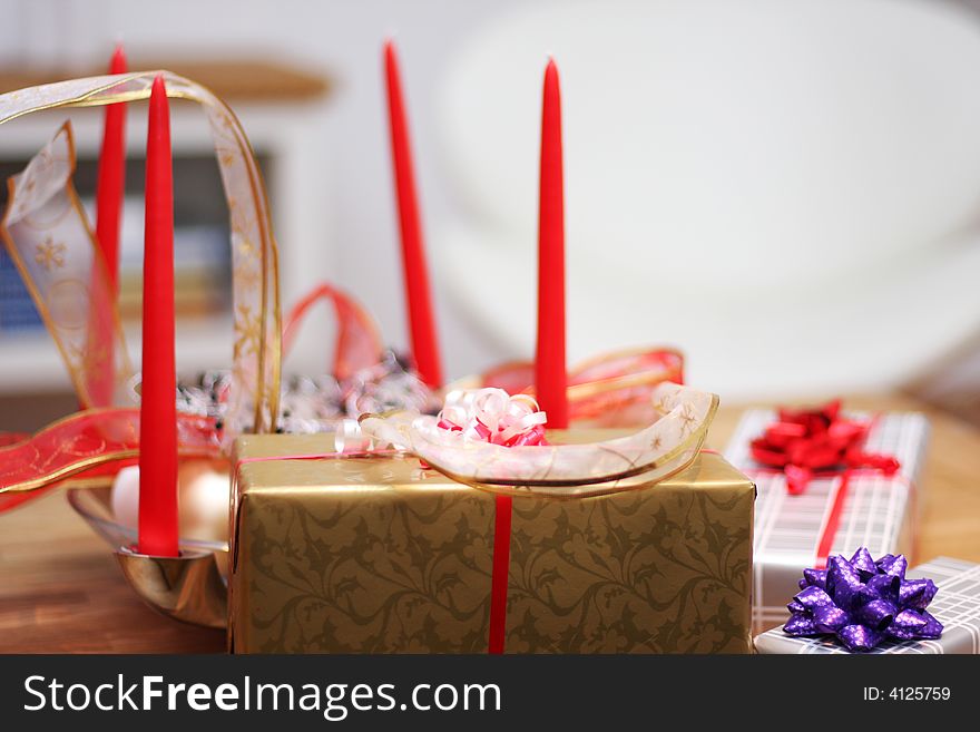Christmas present on a table, ribbons and candle decorations. Christmas present on a table, ribbons and candle decorations