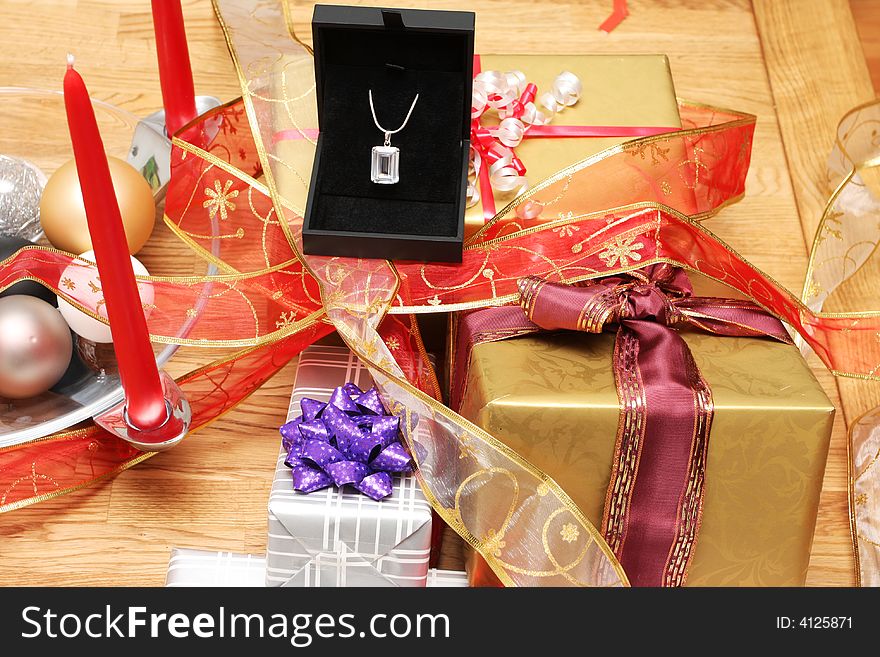 Christmas present on a solid oak table, diamond necklace on top of presents. Christmas present on a solid oak table, diamond necklace on top of presents