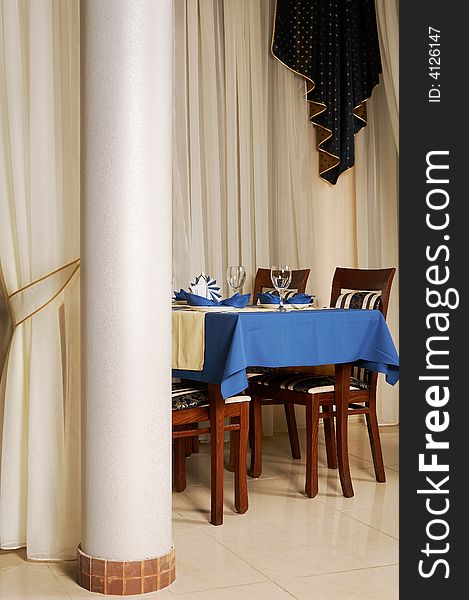 Table with a blue tablecloth at fashionable and modern restaurant