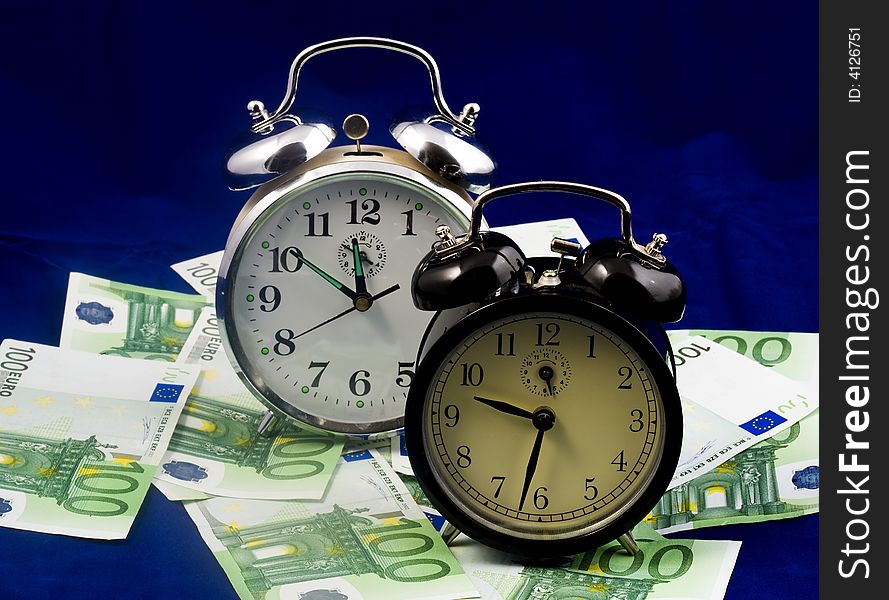 Alarm clocks and euro bills, close up. Alarm clocks and euro bills, close up