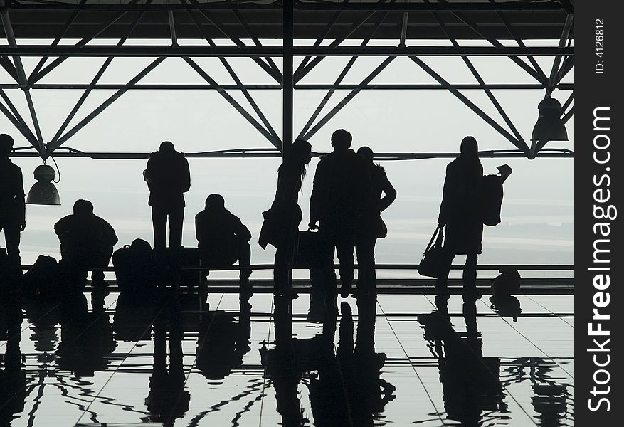 Silhouettes and reflections of passenger waiting at an airport. Silhouettes and reflections of passenger waiting at an airport