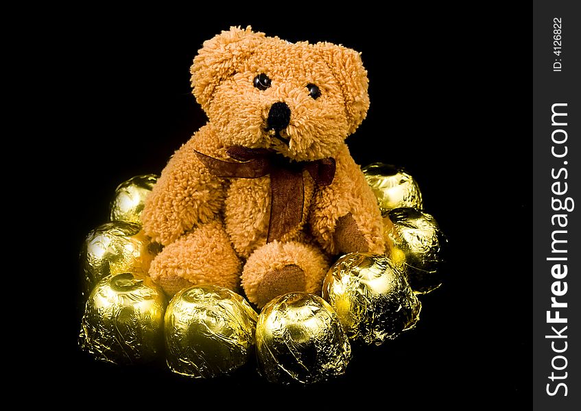 Teddy bear with sweetis on black background