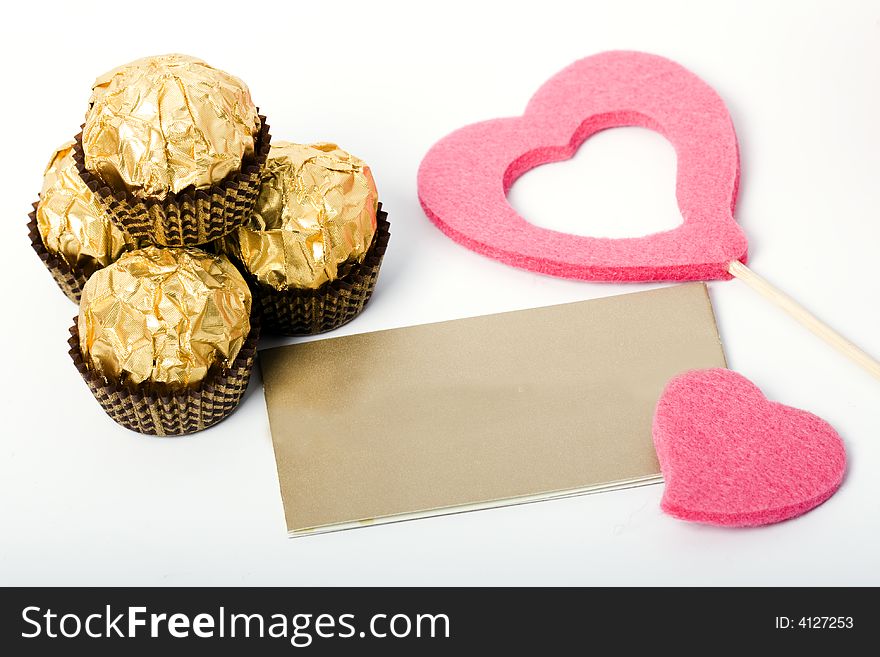 Candies and card and heart shapes on the white background. Candies and card and heart shapes on the white background