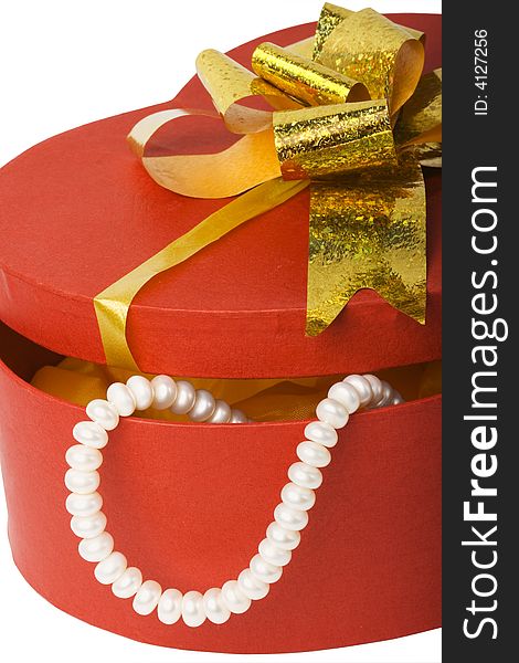 Closeup isolated heart shape box with pearl necklace and gold ribbon. Closeup isolated heart shape box with pearl necklace and gold ribbon