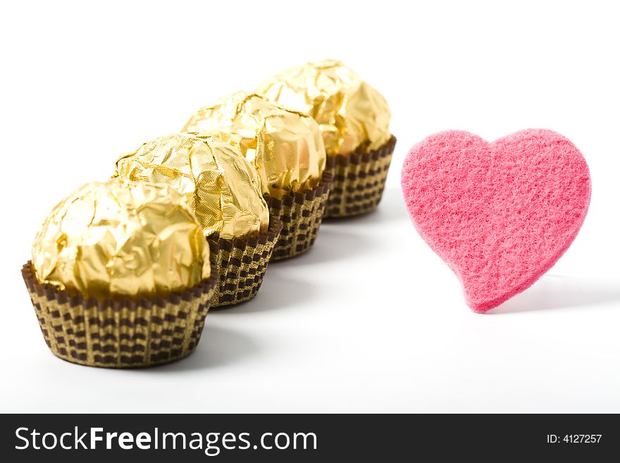 Four sweet gold candies with soft pink heart. Four sweet gold candies with soft pink heart