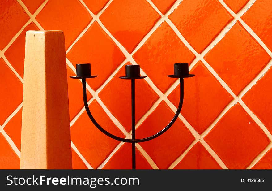 Vase and candle stick on ceramic wall