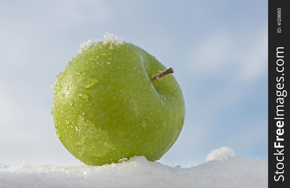 Fresh green apple on snow