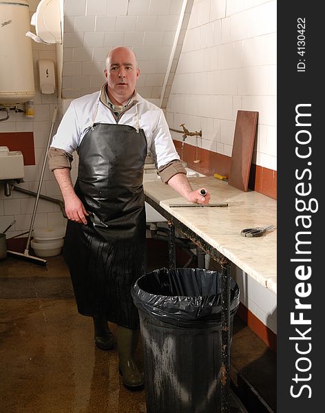 Fishmonger in fish shop wearing black apron. Fishmonger in fish shop wearing black apron
