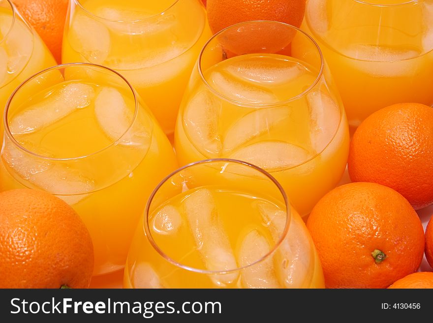 Glasses of freshly squeezed orange juice and oranges.