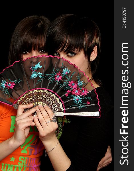 Girls with a spanish fan, on black background