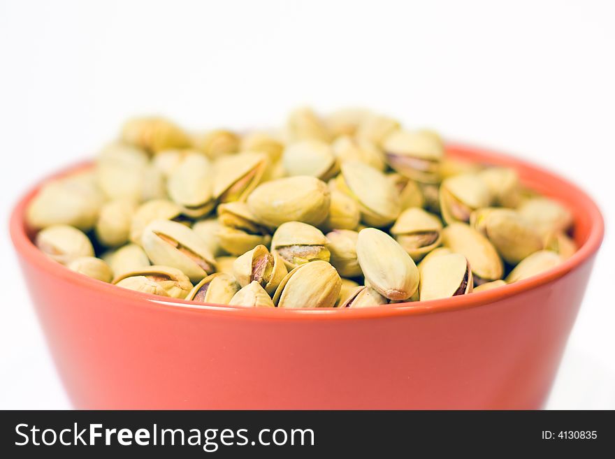 Orange bowl full of pistachios. Orange bowl full of pistachios