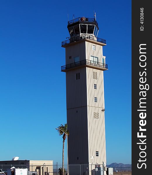 An airport control tower shot against a stunning, clear blue sky. An airport control tower shot against a stunning, clear blue sky