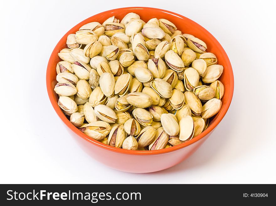 Orange bowl full of pistachios on the white