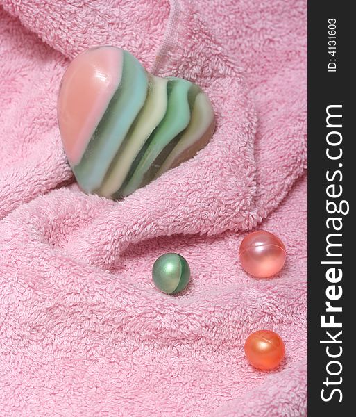 Pink towel,bath oil pearls and soap-heart. Pink towel,bath oil pearls and soap-heart