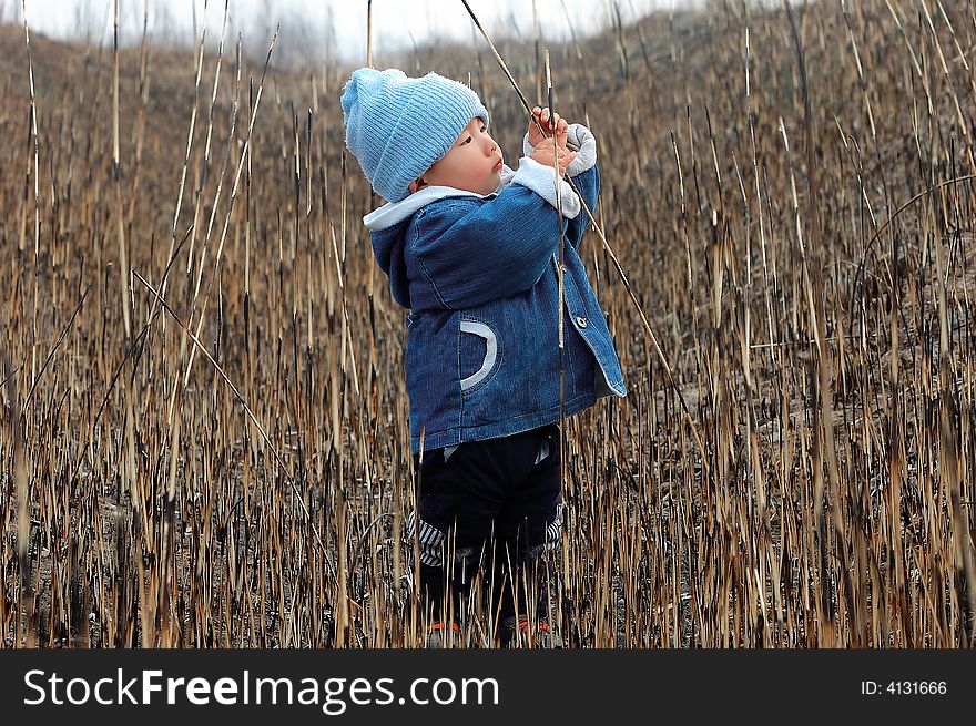 A baby playing in the winter grass field. A baby playing in the winter grass field