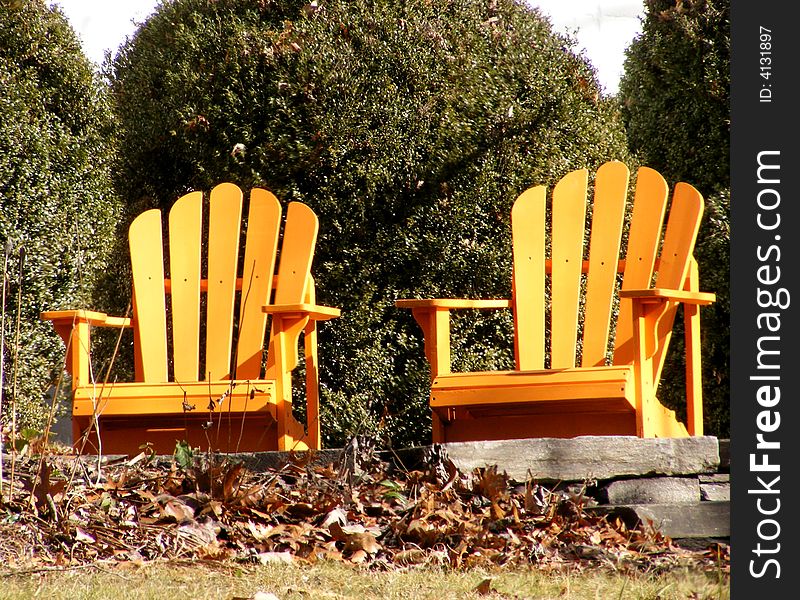 Two adirondack chairs in a bright color.